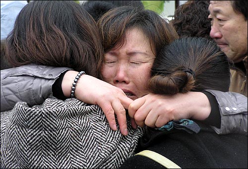 대구지하철 참사 2주기 추모식에서 한 유족이 가족들을 껴안은채 오열하고 있다. 